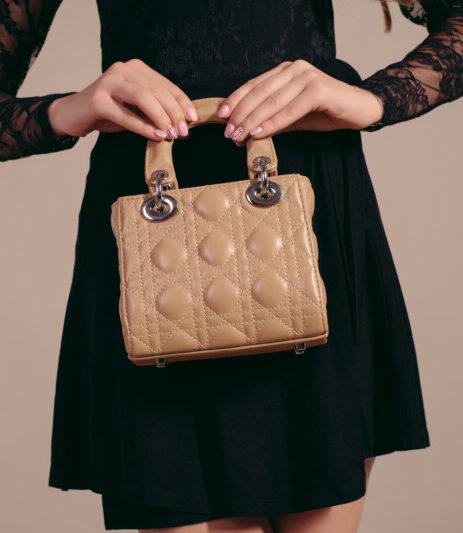young woman posing black dress handbag e1741540319579