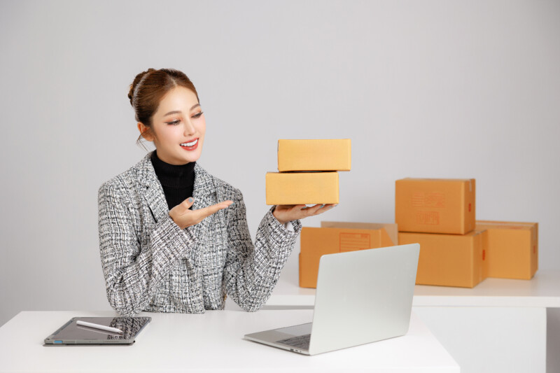 asian smart entrepreneur business woman casual suit surround by parcel boxes using computer laptop internet service customer online marketing check package home store sme concept